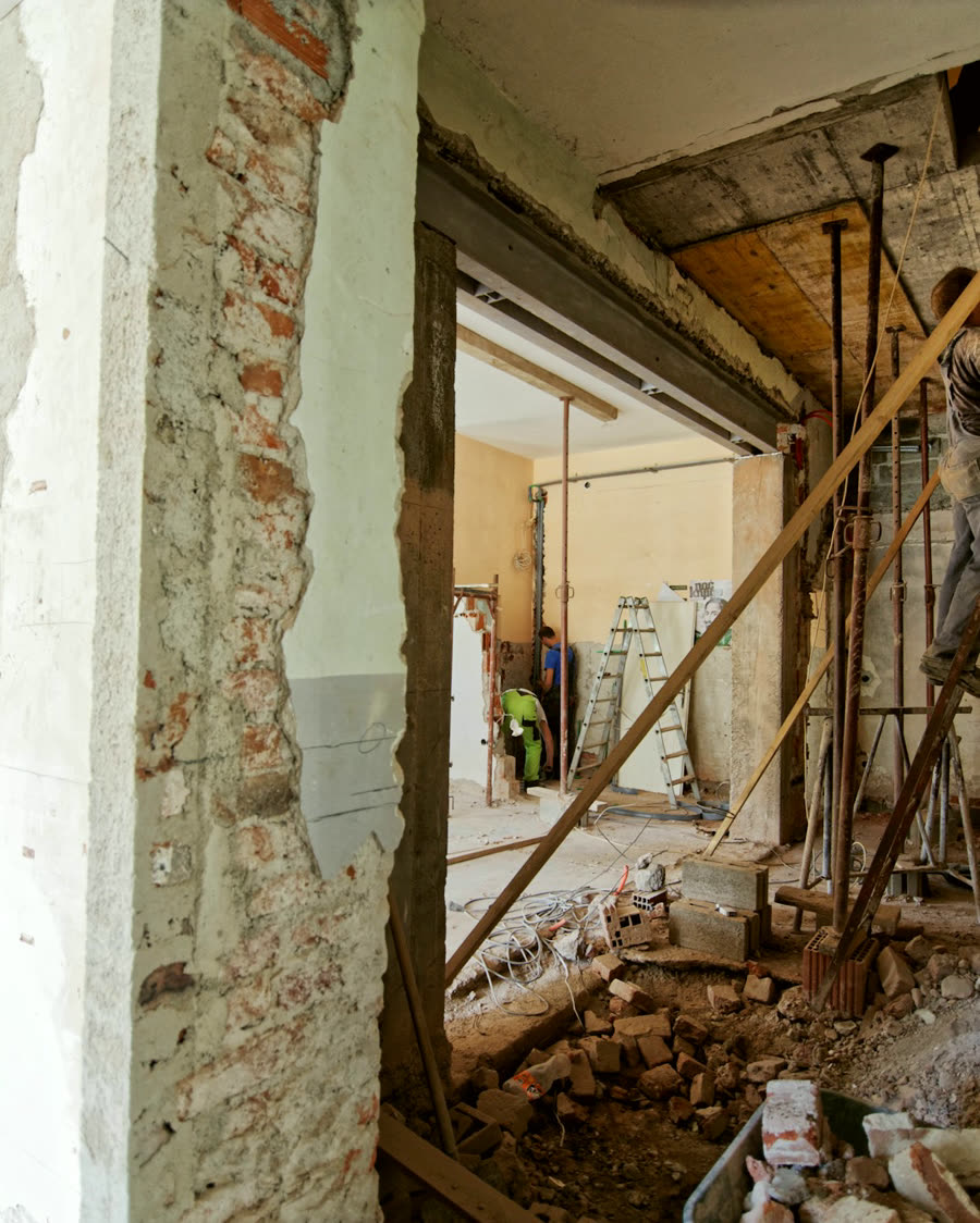 A wall opened to the studs during rough-in, framing and brick exposed